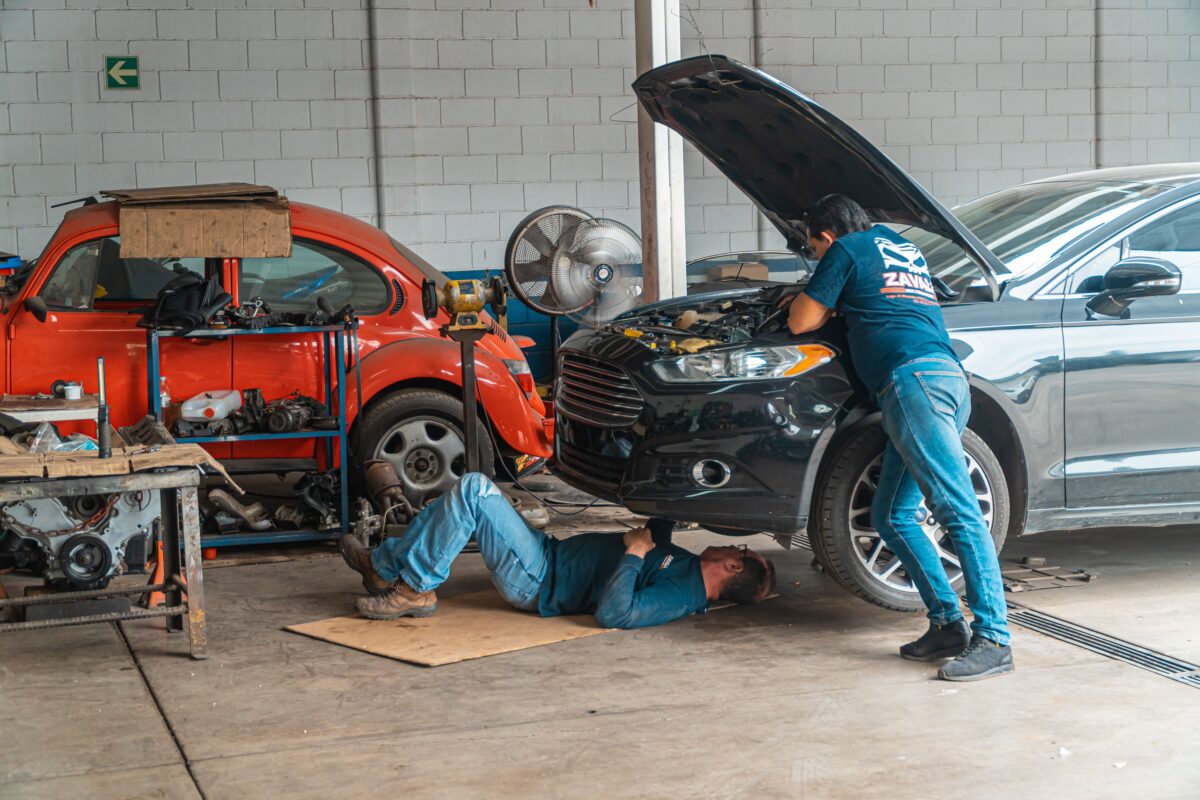 Mechanic working underneath a vehicle in an automotive garage