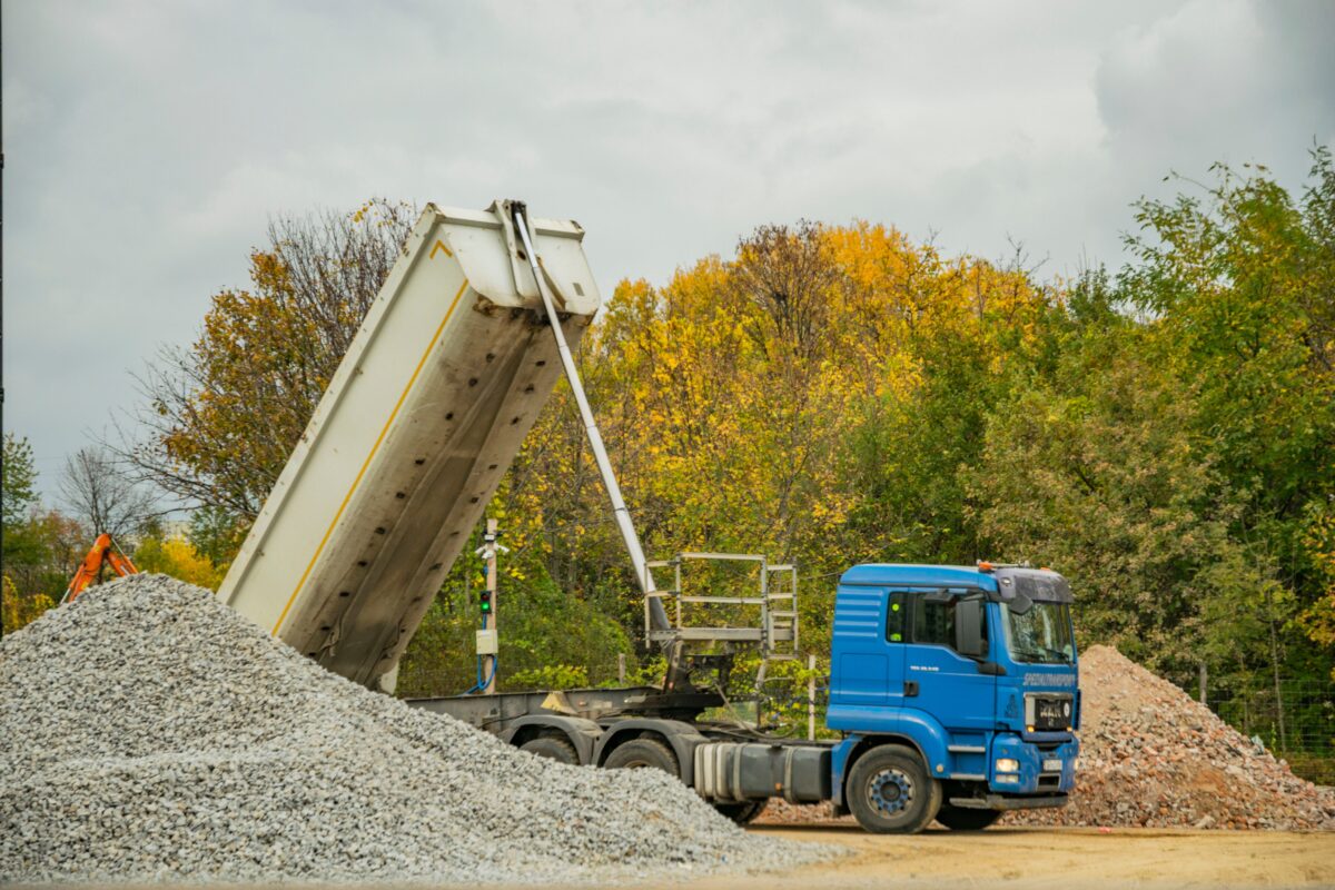 Dump truck tipping gravel at a forestry or quarry site